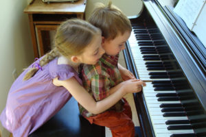 Children playing piano with Music Teacher LA